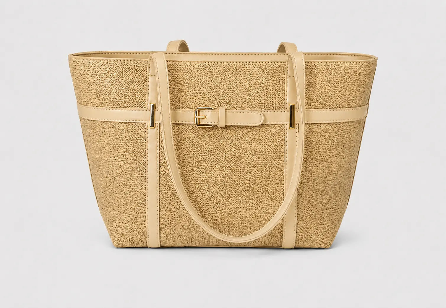 A structured tote bag made of natural woven straw material, featuring light tan leather trim, double shoulder straps, and a central horizontal strap with a gold-tone buckle closure, set against a plain light gray background.