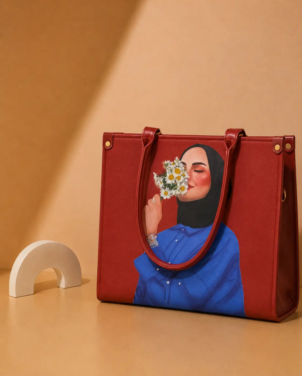 Red handbag with a design of a woman holding flowers on a beige background