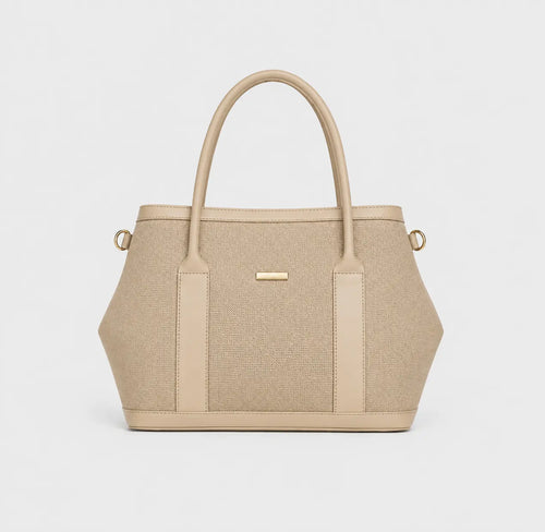 A structured beige handbag with a textured woven body, smooth beige leather trim, dual top handles, and small gold-tone hardware, shown on a clean light gray background.