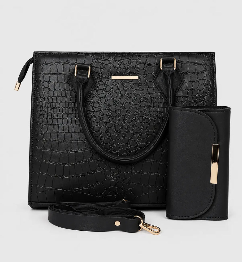 Black crocodile-embossed tote bag with dual top handles, a detachable shoulder strap, a matching vertical wallet, and gold-tone hardware, shown on a light gray background.