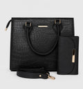 Black crocodile-embossed tote bag with dual top handles, a detachable shoulder strap, a matching vertical wallet, and gold-tone hardware, shown on a light gray background.