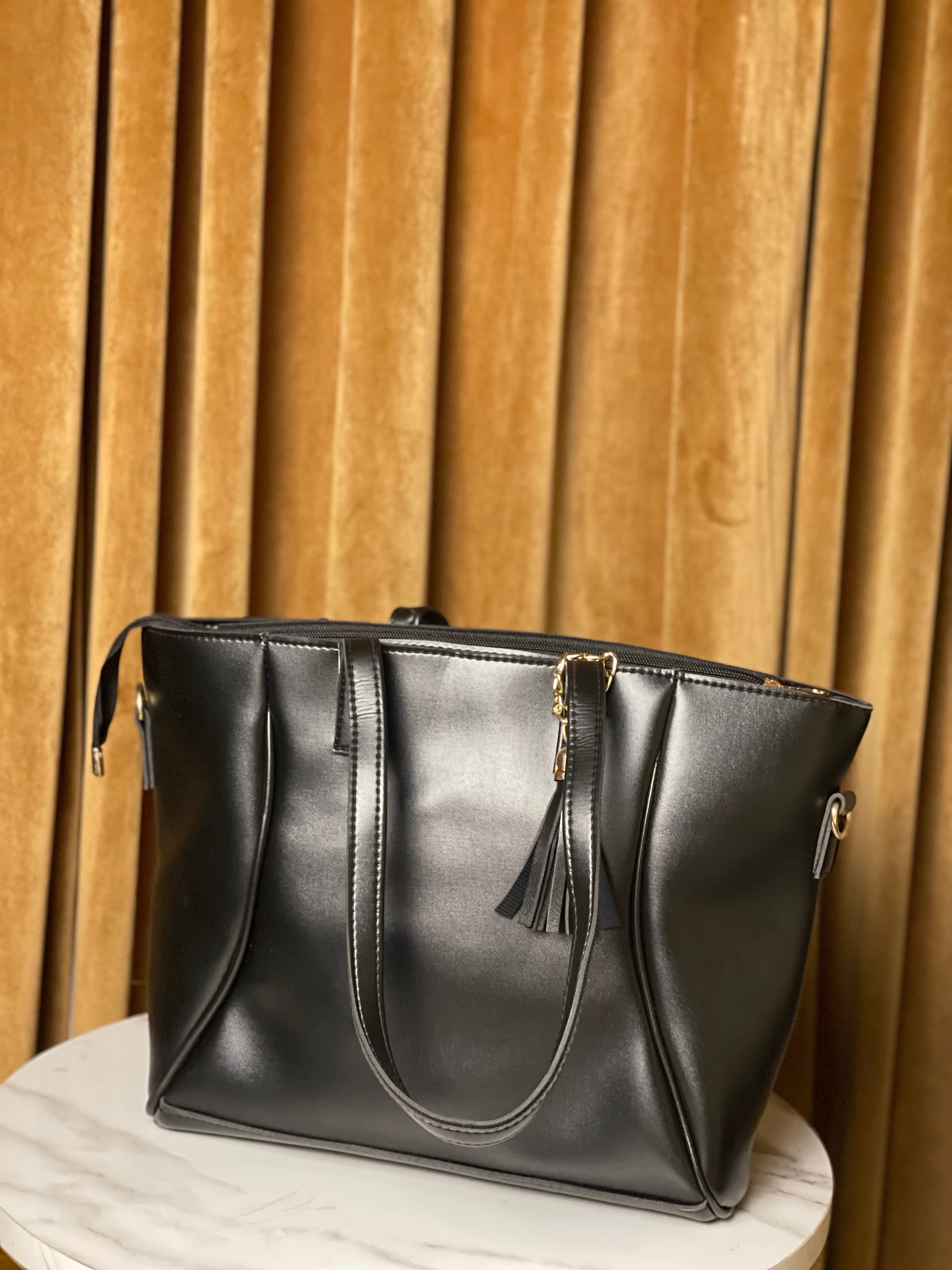 Black handbag with a tassel and long strap
