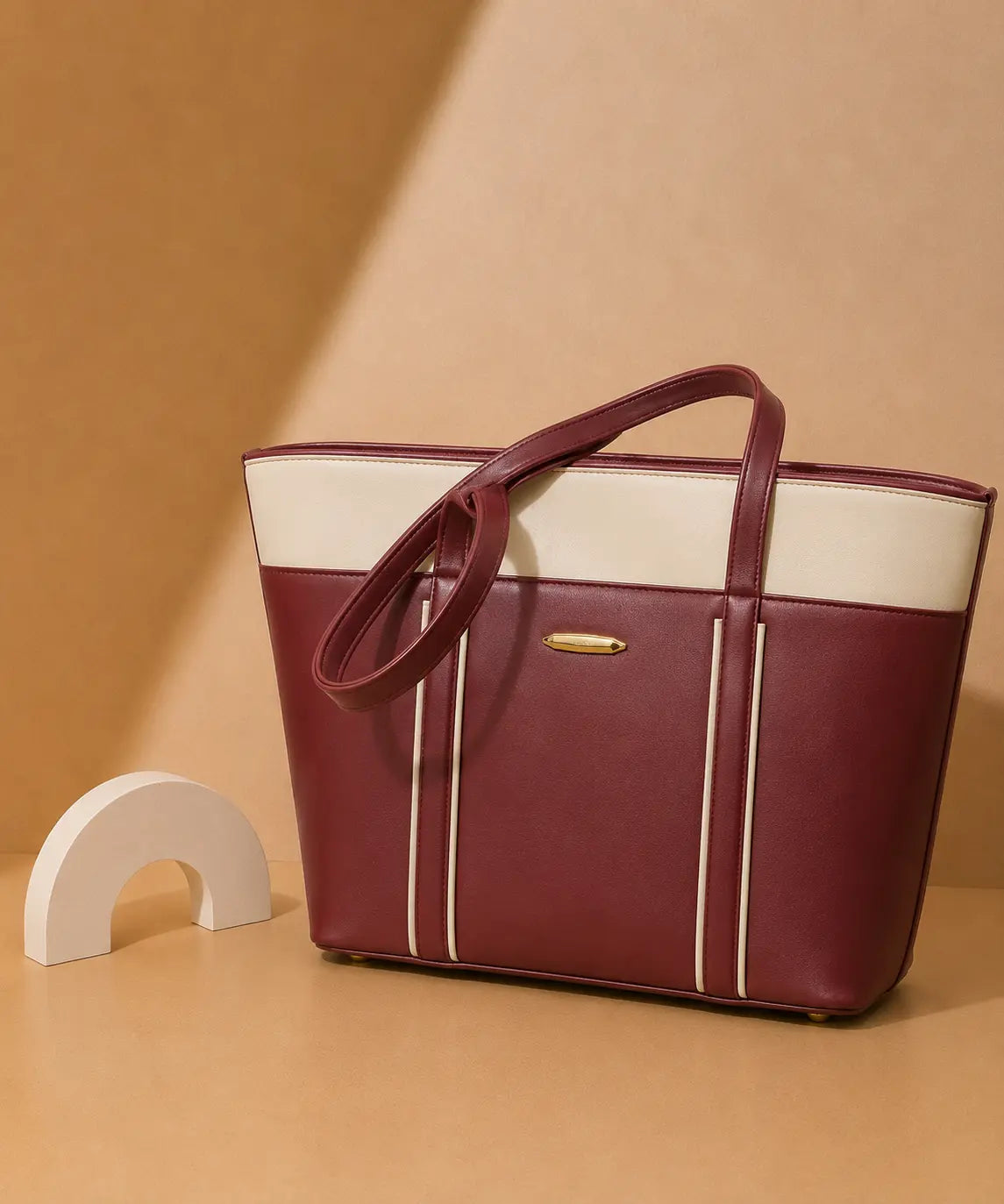 Maroon and white handbag on a beige background