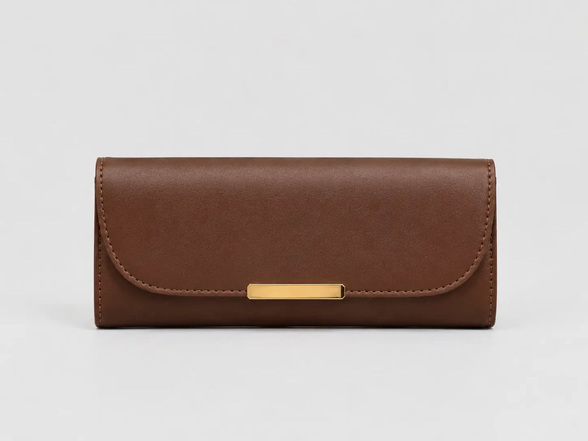 A brown leather long wallet or clutch with a curved flap and a horizontal gold-tone metal bar clasp, shown against a light gray background.