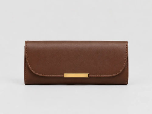 A brown leather long wallet or clutch with a curved flap and a horizontal gold-tone metal bar clasp, shown against a light gray background.