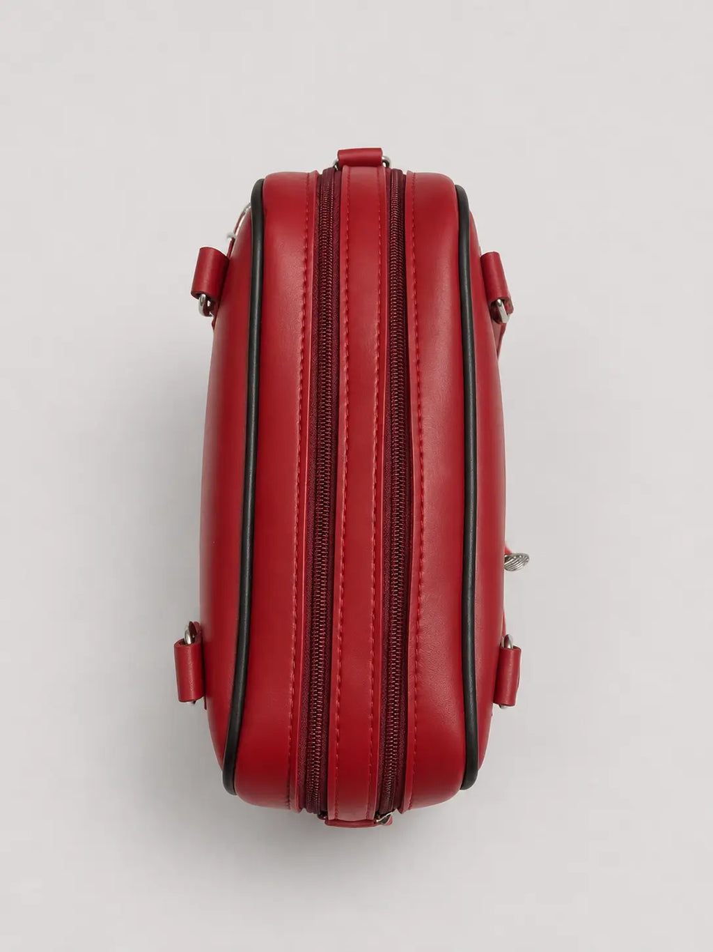A red leather double-zipper clutch bag shown from a top-down view on a light gray background.