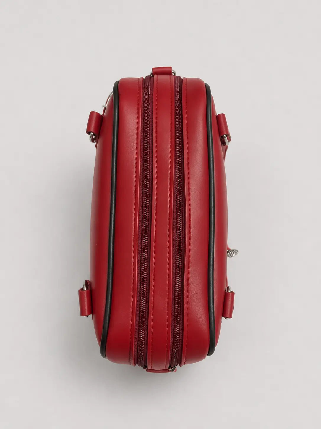A red leather double-zipper clutch bag shown from a top-down view on a light gray background.