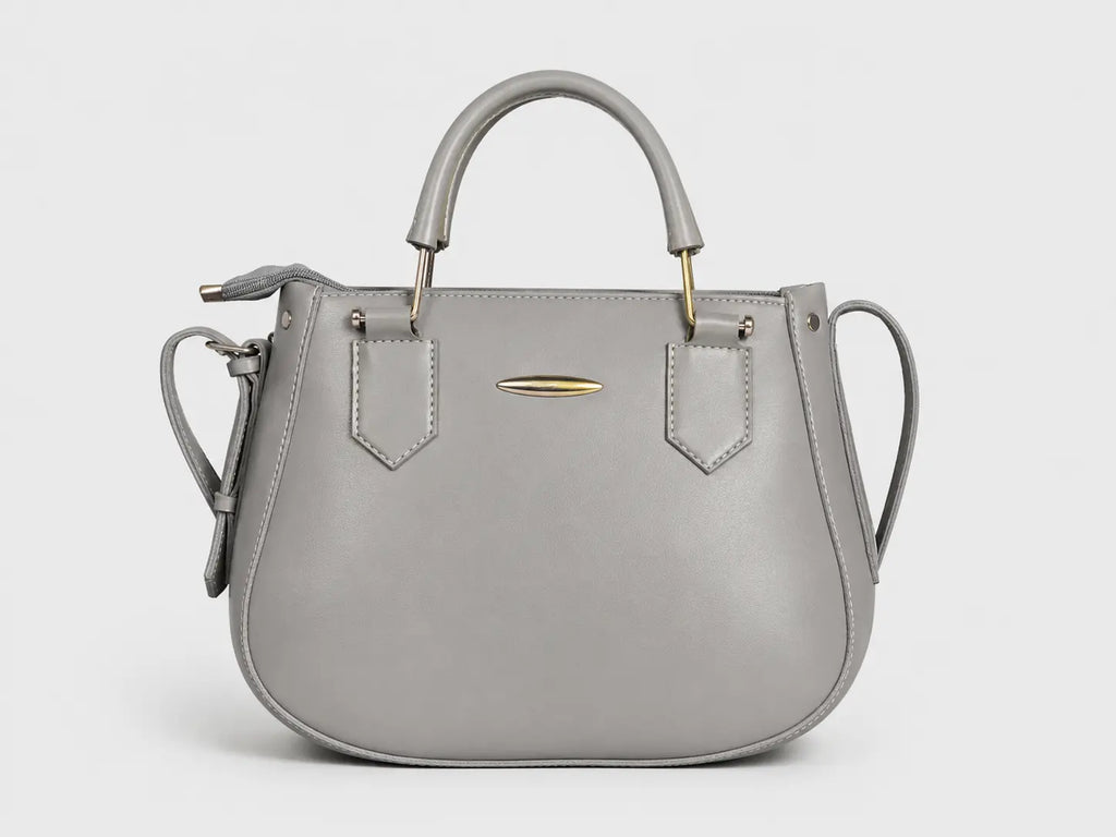 A light gray leather handbag with a top handle, shoulder strap, and gold-tone hardware, shown against a plain light gray background.