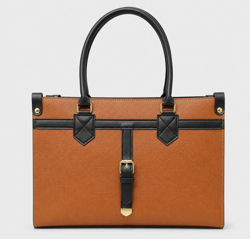 A structured tan leather handbag with black leather handles, trim, and strap details, accented by gold-tone hardware, shown against a light gray background.