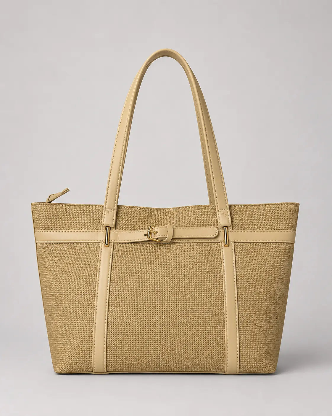 A structured tote bag in a woven beige texture with smooth beige leather trim, double shoulder straps, and a decorative buckle detail on the front, shown against a neutral light gray background.