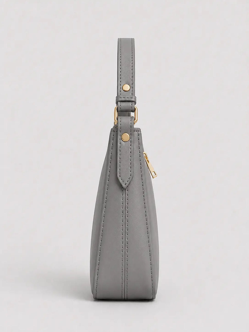 A gray leather shoulder bag shown from the side, featuring a slim strap, gold-tone hardware, and a zippered closure, set against a light gray background.