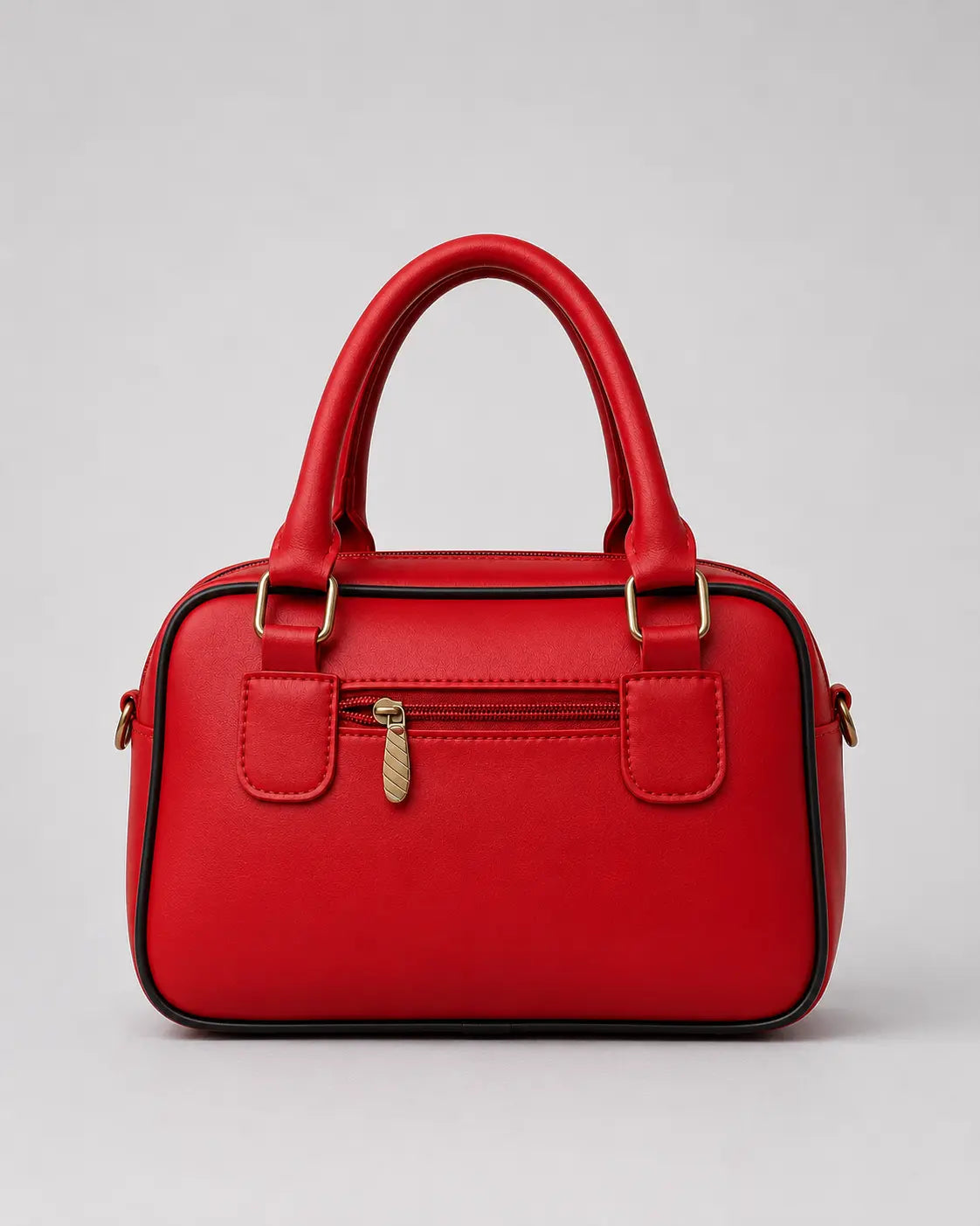 A bright red faux leather handbag with double top handles, a front zippered pocket with a gold-tone zipper pull, and gold-tone hardware, shown against a neutral gray background.