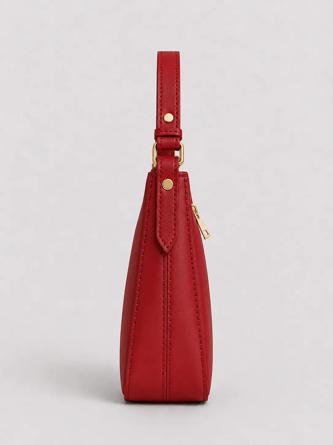A red leather shoulder bag shown from the side profile against a light gray background, featuring gold-tone hardware and a zippered closure.