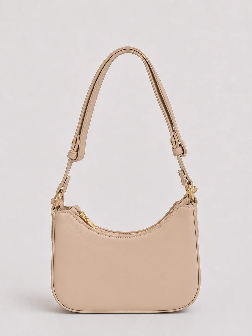 A light beige leather crescent-shaped shoulder bag with gold-tone hardware and a matching adjustable shoulder strap, shown against a neutral light gray background.