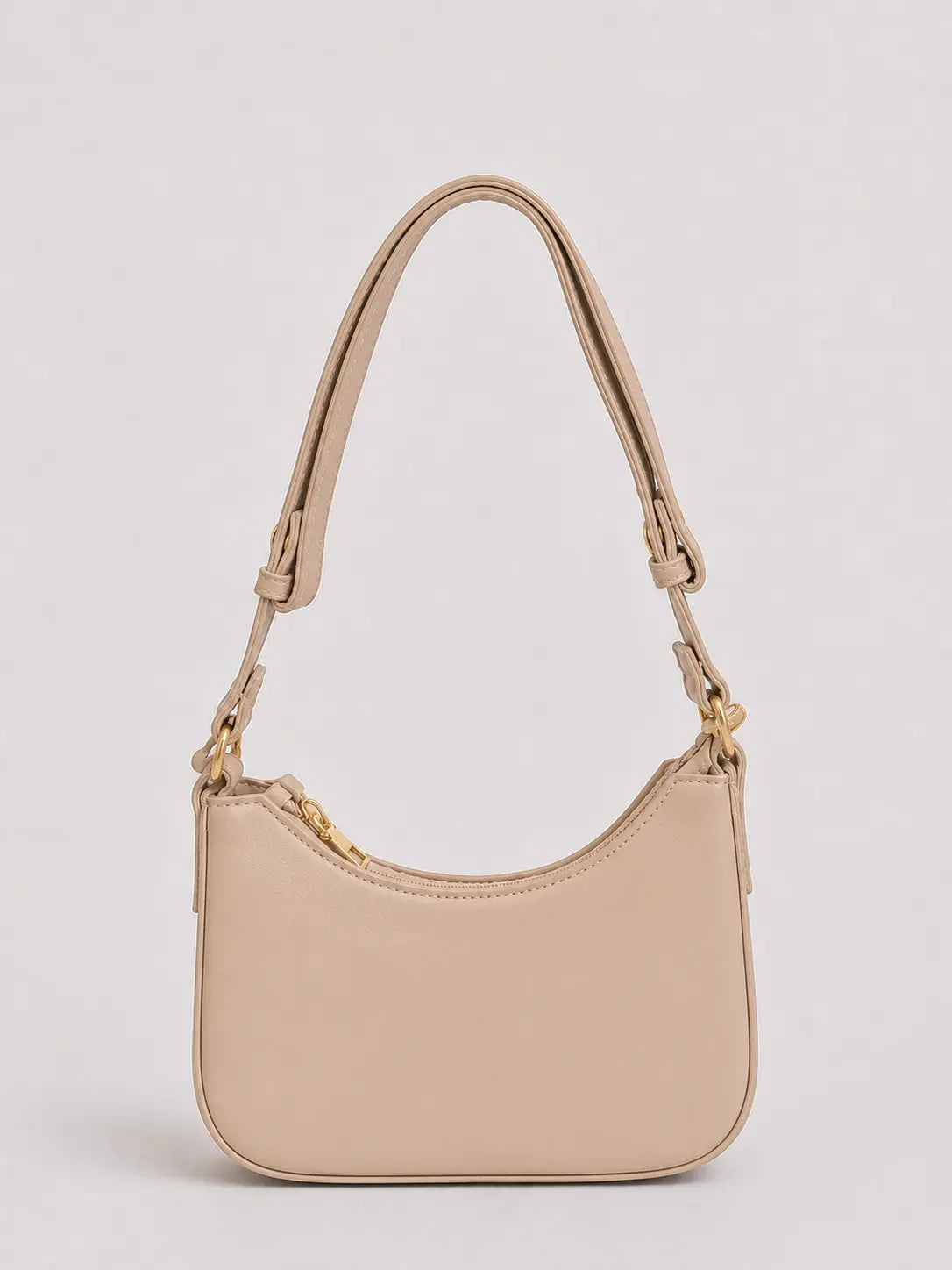A light beige leather crescent-shaped shoulder bag with gold-tone hardware and a matching adjustable shoulder strap, shown against a neutral light gray background.